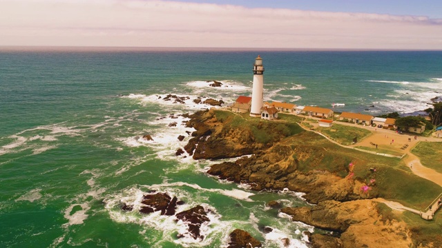 灯塔无人机拍摄空中直升飞机查看海岸与撞击的海浪日落4K视频素材