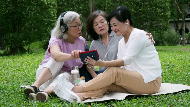 三位女士在公园里一起听音乐视频素材