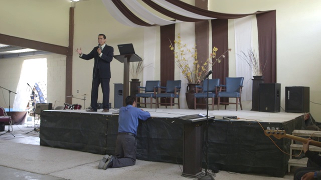 牧师在教堂里引导着祈祷者，宽镜头视频素材