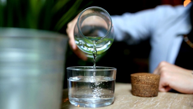 近距离从桌上的瓶子里倒出纯净的新鲜饮用水视频素材