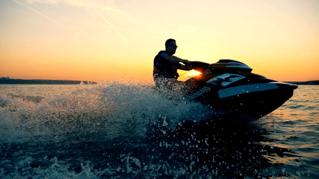 一个人在美丽的夕阳下乘坐喷气快艇的过程视频素材