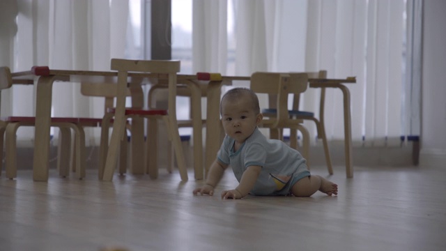 小女孩在家里的木地板上爬行/重庆，中国视频下载