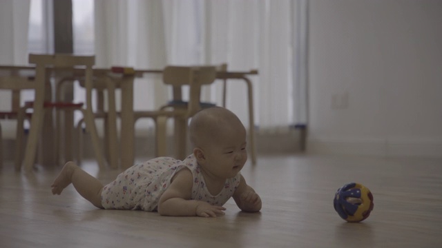小女孩在家里的木地板上爬行/重庆，中国视频下载