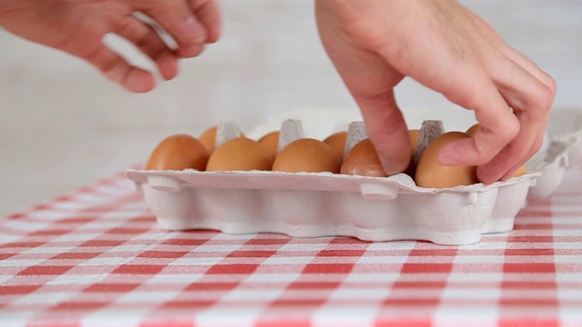 男人的手从纸板包装鸡蛋。慢动作视频下载