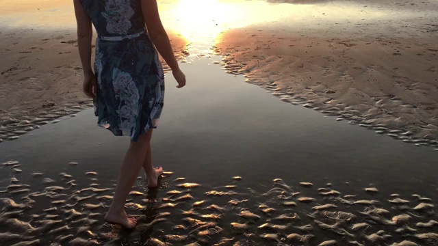 澳大利亚妇女走在明迪尔海滩在日落在达尔文北领地澳大利亚视频下载