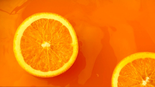 新鲜的橙子飞溅到橙汁中视频素材