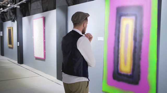 现代抽象艺术家展览的男观众在看画视频素材