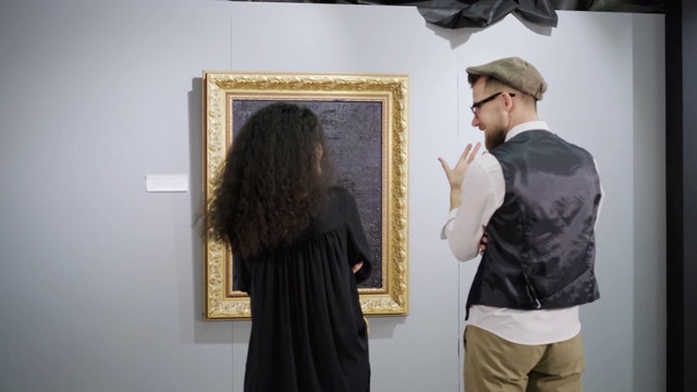 一对参观现代艺术展的人正在画前聊天视频素材