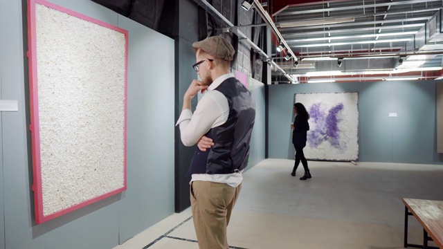 一名男性参观者正在观看现代抽象艺术家的绘画作品视频素材