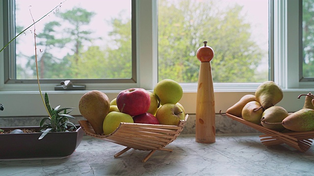 新鲜水果，苹果和桃子，在现代厨房的窗台上。
全景相机运动。视频下载