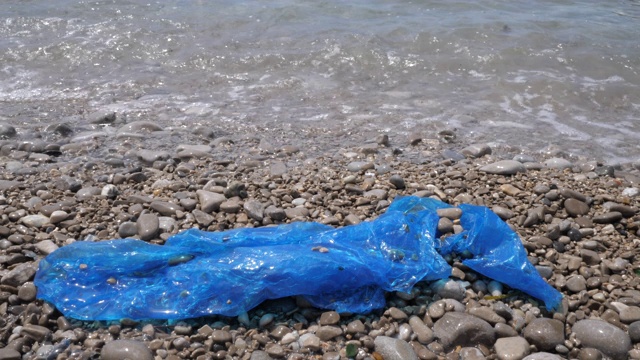 海滩上的塑料袋。污染水的概念。视频素材