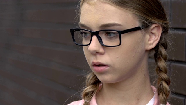 十几岁的学生嘲笑戴眼镜的漂亮女孩，辱骂，欺负视频素材