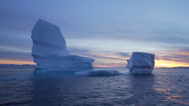 巨大的冰山漂浮在海上，对着天空，格陵兰岛的迪斯科湾视频下载