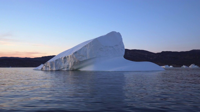 日落时分，格陵兰岛迪斯科湾的白色冰山被冻住了视频下载