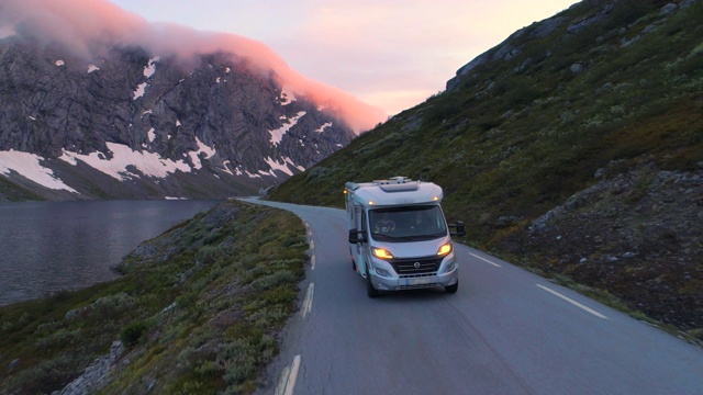 日落时分，游客乘坐露营车沿着山脉和峡湾行进——盖兰格峡湾，挪威视频下载