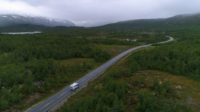 航拍:无人机拍摄的房车行驶在挪威奥普兰森林沿线的道路上视频素材