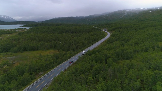 航拍:无人机拍摄的车辆在树林中行驶的画面——挪威奥普兰视频素材