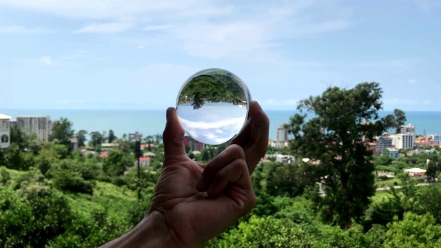 手握魔法水晶球越过美丽的自然景观，旅行的概念视频下载