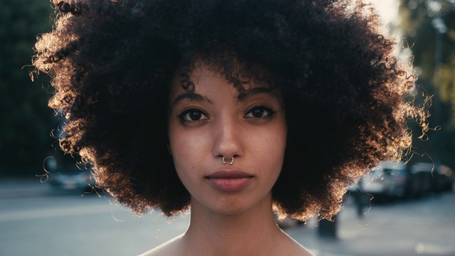 日落时分城市里一个留着非洲式发型的年轻女子的肖像视频素材
