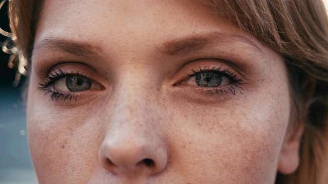 一个年轻的成年妇女的肖像在日落，打开和关闭她的蓝色眼睛视频购买