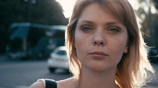 一个年轻的成年妇女的肖像在日落，打开和关闭她的蓝色眼睛视频素材