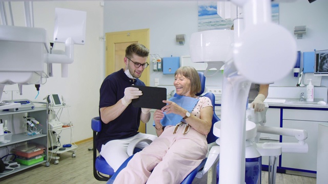 愉快的牙医和病人在诊所讨论视频素材