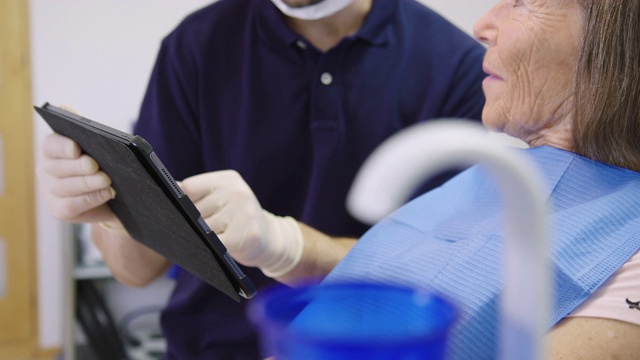 微笑的病人与牙医交谈，拿着药片视频素材