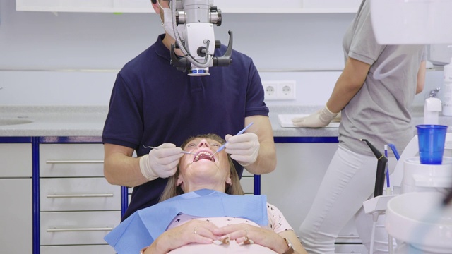 牙医在用牙科显微镜观察视频素材