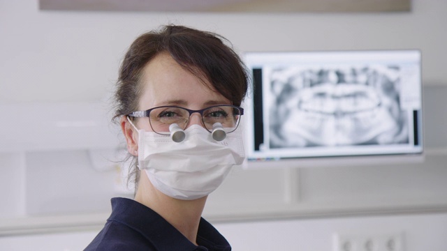 戴外科口罩和放大镜的女牙医视频素材