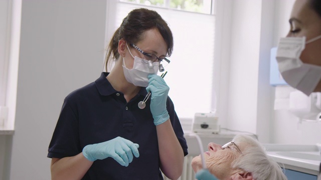 牙科医生和助理检查老年病人视频素材
