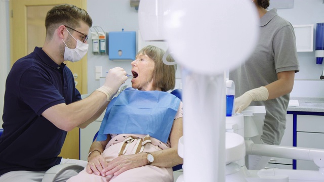 牙科医生在诊所检查老年病人的牙齿视频素材