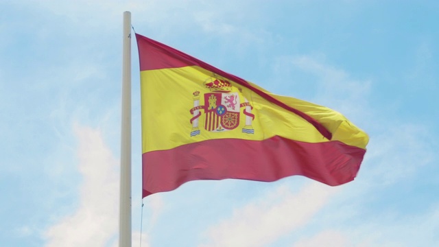 西班牙的国旗。在湛蓝的天空下，旗杆上红黄相间的西班牙国旗迎风飘扬视频下载