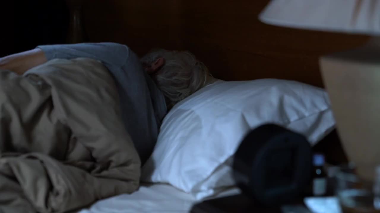 一个沮丧的老人躺在床上无法入睡视频素材