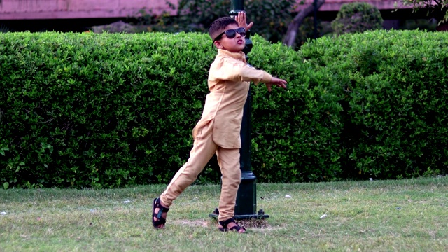 小男孩戴着太阳镜，在夏天的公园里开心地跳舞视频下载