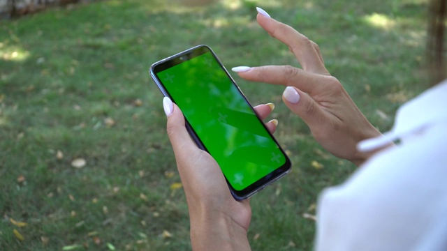 女人拿着智能手机绿色屏幕的特写，色makey视频素材