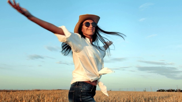 快乐旅行时尚女人跳舞跳跃在麦田的背景中拍摄的乐趣视频下载