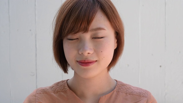 近距离的大头照片的年轻日本女子打开眼睛和微笑的相机微笑视频素材