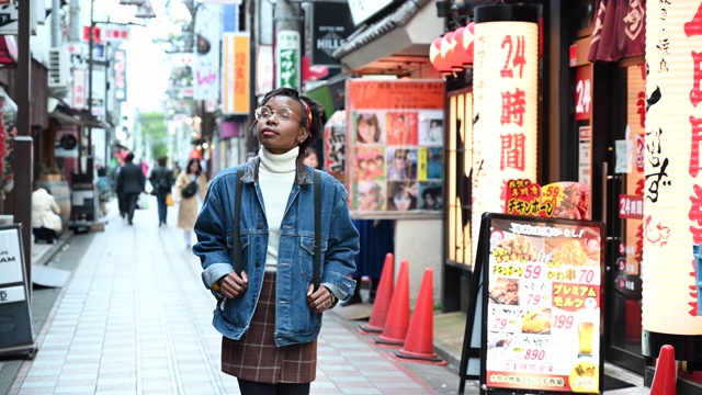 年轻的非洲妇女走在东京的街道上视频素材