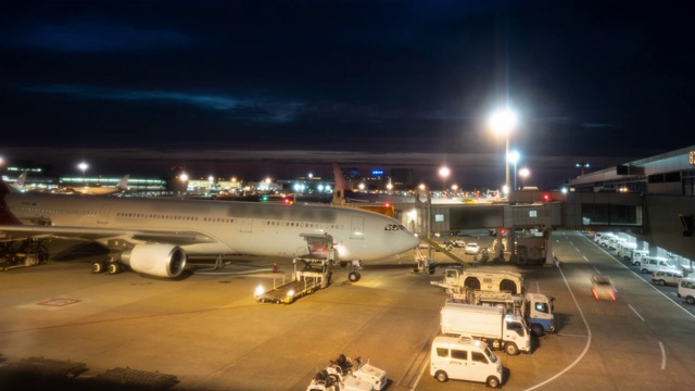 延时:黄昏时分，在机场，货运汽车将货物和行李装载到飞机上视频素材