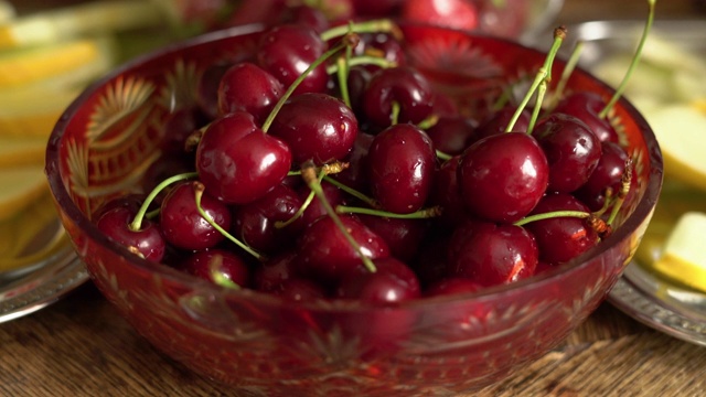 新鲜的夏季水果-樱桃在旧木桌上的古董水晶碗视频下载