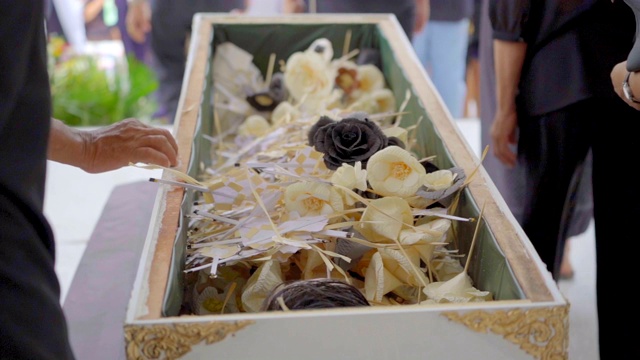 慢镜头中人们经过棺材中的檀香花，死亡的人在火葬场中视频下载