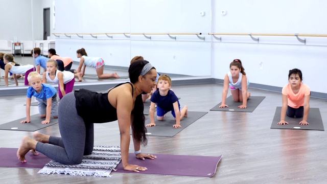 自信的女性瑜伽教练教一群孩子视频下载
