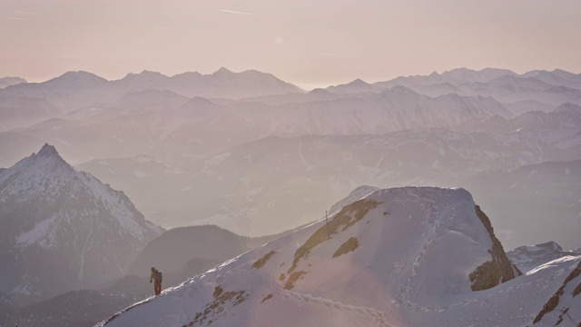 一名徒步旅行者在雪山山顶卷绳子视频素材