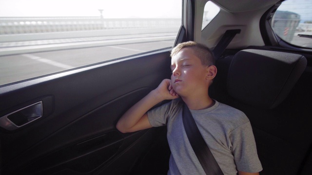 那个男孩碍手碍脚地睡在车里视频素材