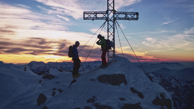 日出时，山顶上的徒步旅行者在天空的映衬下穿过视频素材
