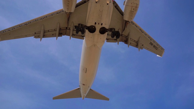 一架飞机在机场降落前从游客头顶飞过的热带海滩的超慢速镜头视频下载