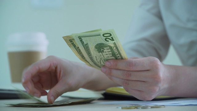 一个女人在数美元钞票的特写视频素材