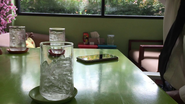 将水从壶中倒入装有冰的玻璃杯中视频素材