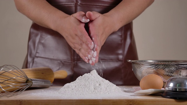 手面包师刷去面粉上的手视频素材