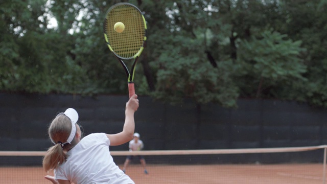 网球，体育运动员少女与对手击球拍球在球场上互相传递网视频下载